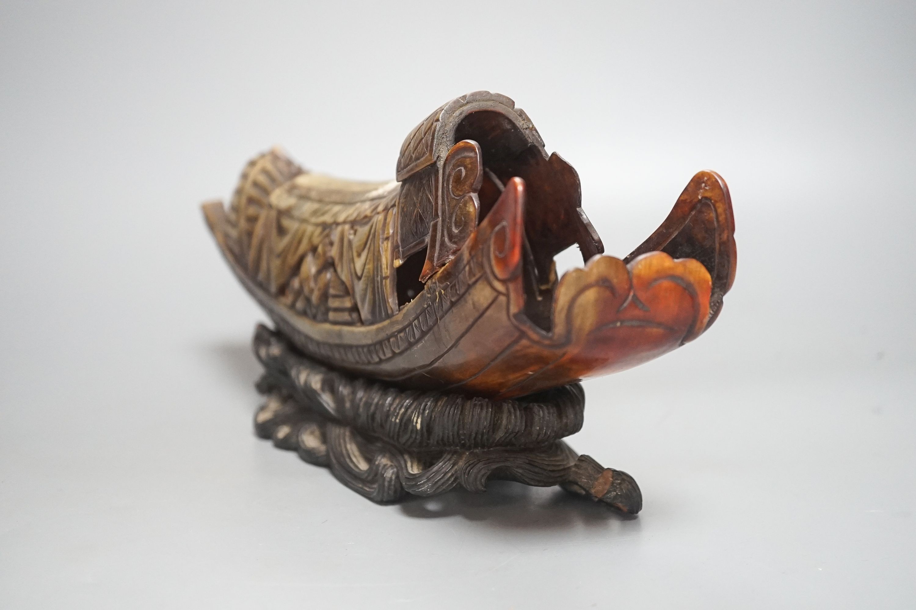 A Chinese horn carving of a junk boat, wood stand, 34cm